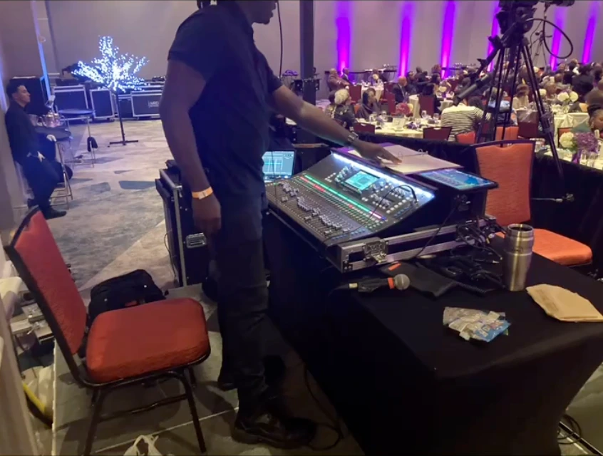 An audio engineer at the mixing console in the conference ballroom.